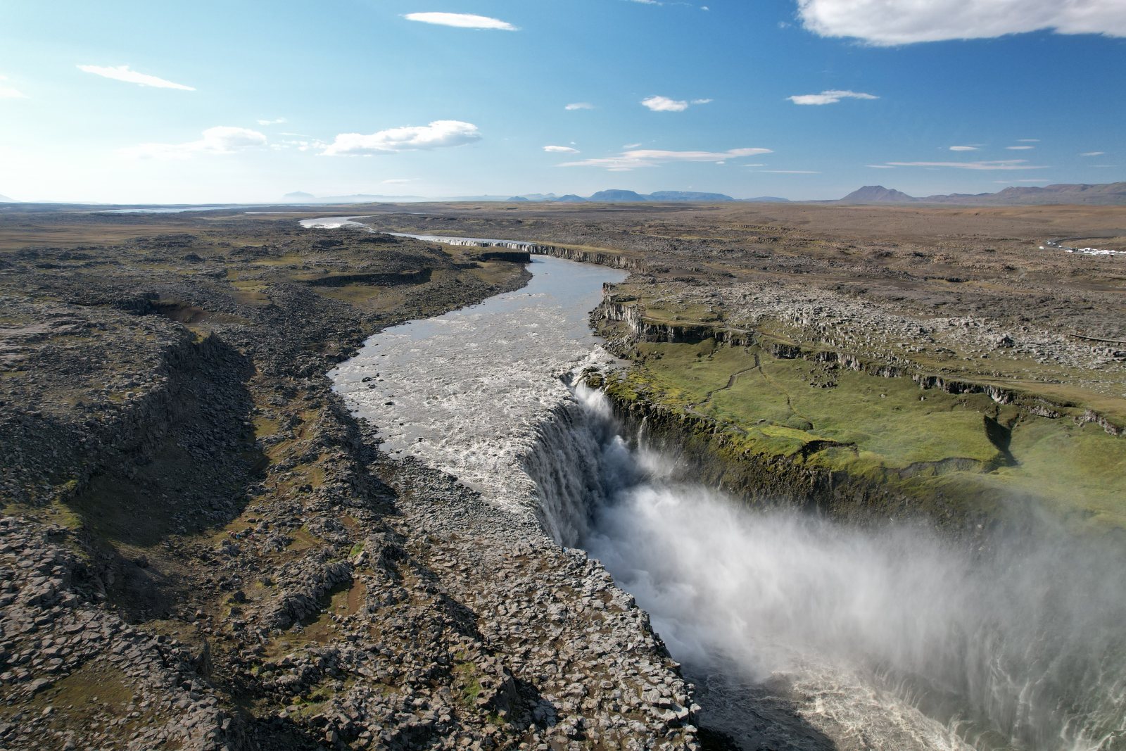 Fiume che precipita in un canyon roccioso con vegetazione verde, vista aerea
