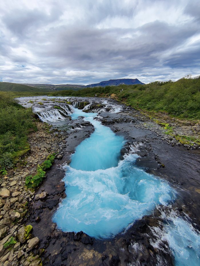 Acqua di un turchese intenso che scende in cascata fra le rocce