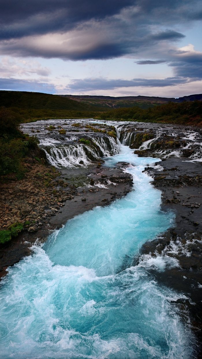 Acqua che scorre e cade su rocce in un paesaggio naturale