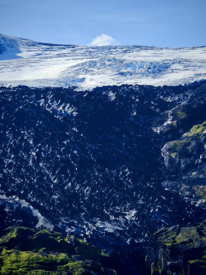 Ghiacciaio visto da un terreno vulcanico coperto di muschio