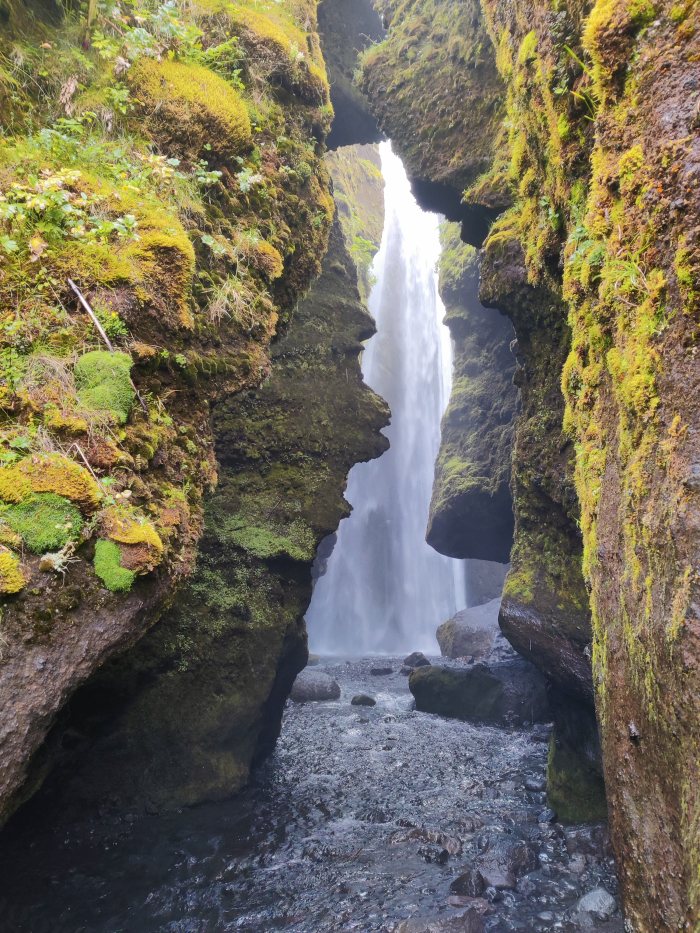 Cascata che scorre fra rocce ricoperte di muschio