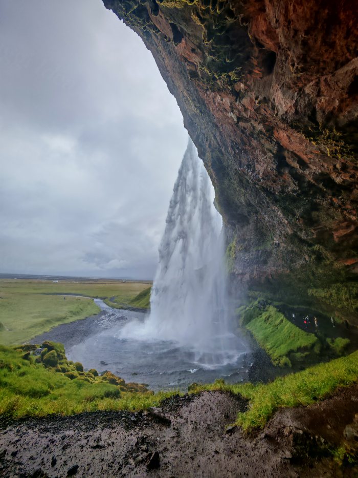 Visitatori osservano la cascata che scende dalla scogliera verso il fiume