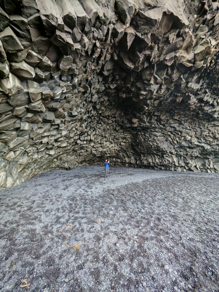 Una persona in piedi dentro una grotta di lava