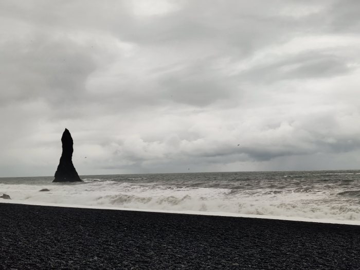 Onda che si infrange su una spiaggia di ciottoli neri