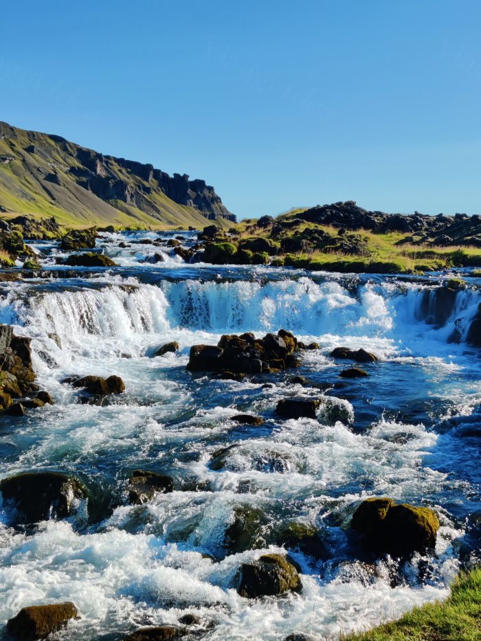 Acqua che scorre su rocce in un paesaggio montuoso