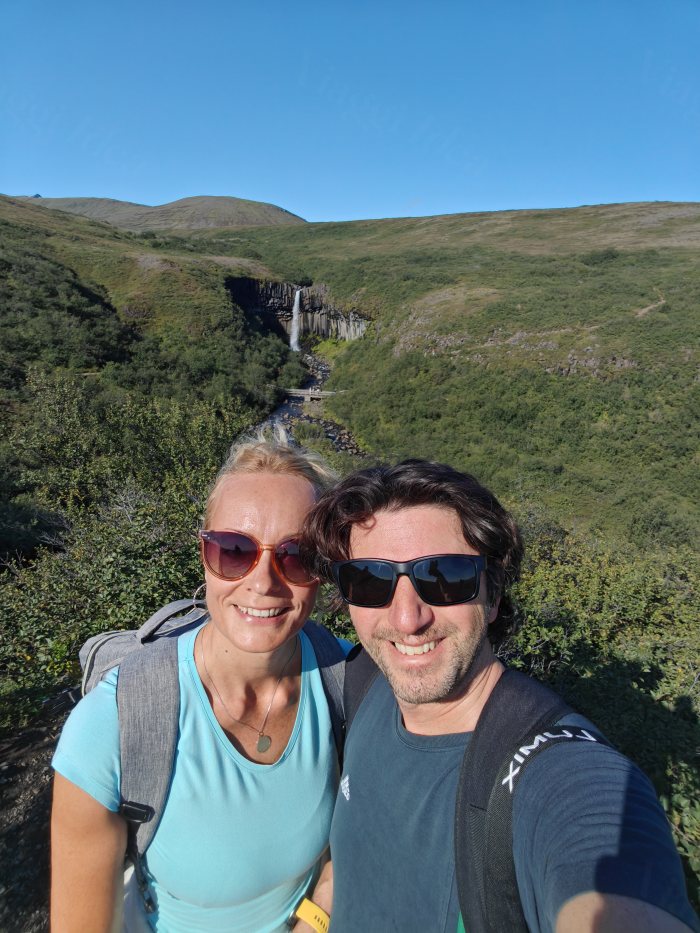 Selfie di coppia davanti a un canyon con cascata