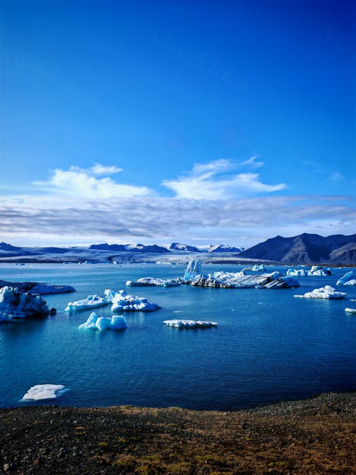 Lago glaciale con iceberg galleggianti sotto cielo azzurro