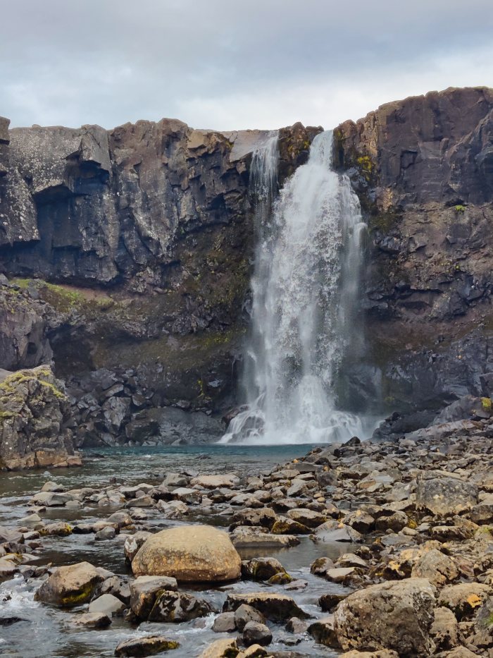 Cascata che cade su rocce scure in un ambiente naturale