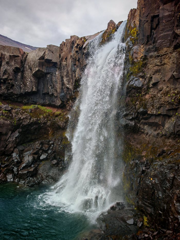 Acqua che cade da una parete rocciosa in un bacino
