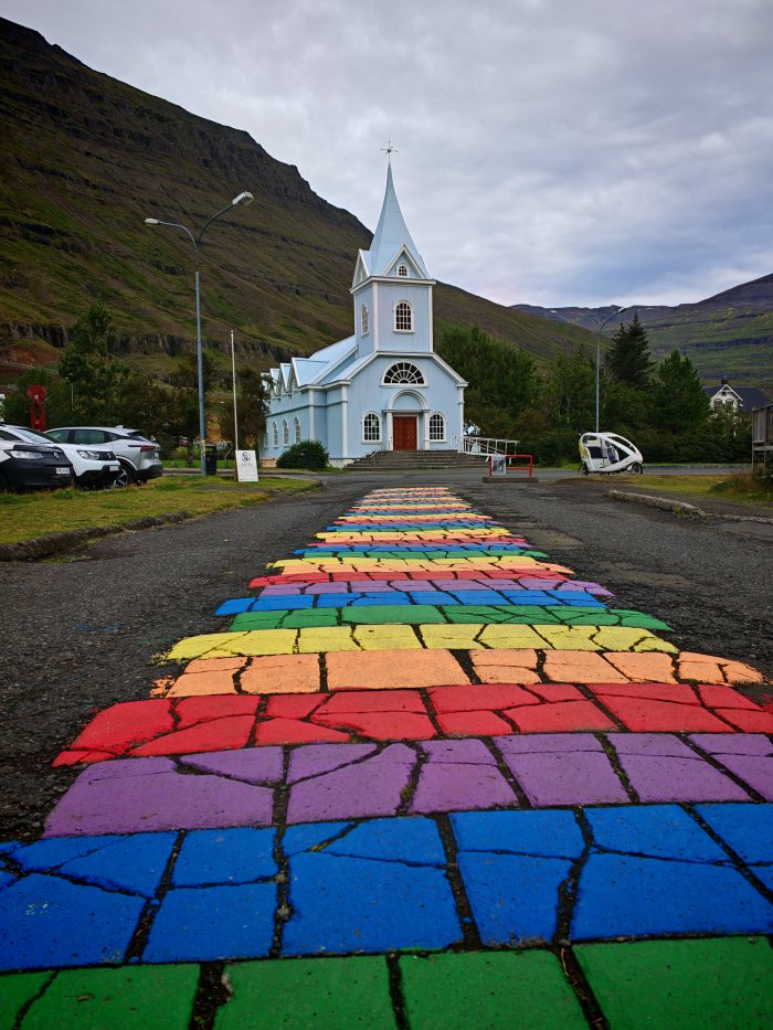 Chiesa azzurra con un sentiero dipinto a strisce arcobaleno che porta all'ingresso