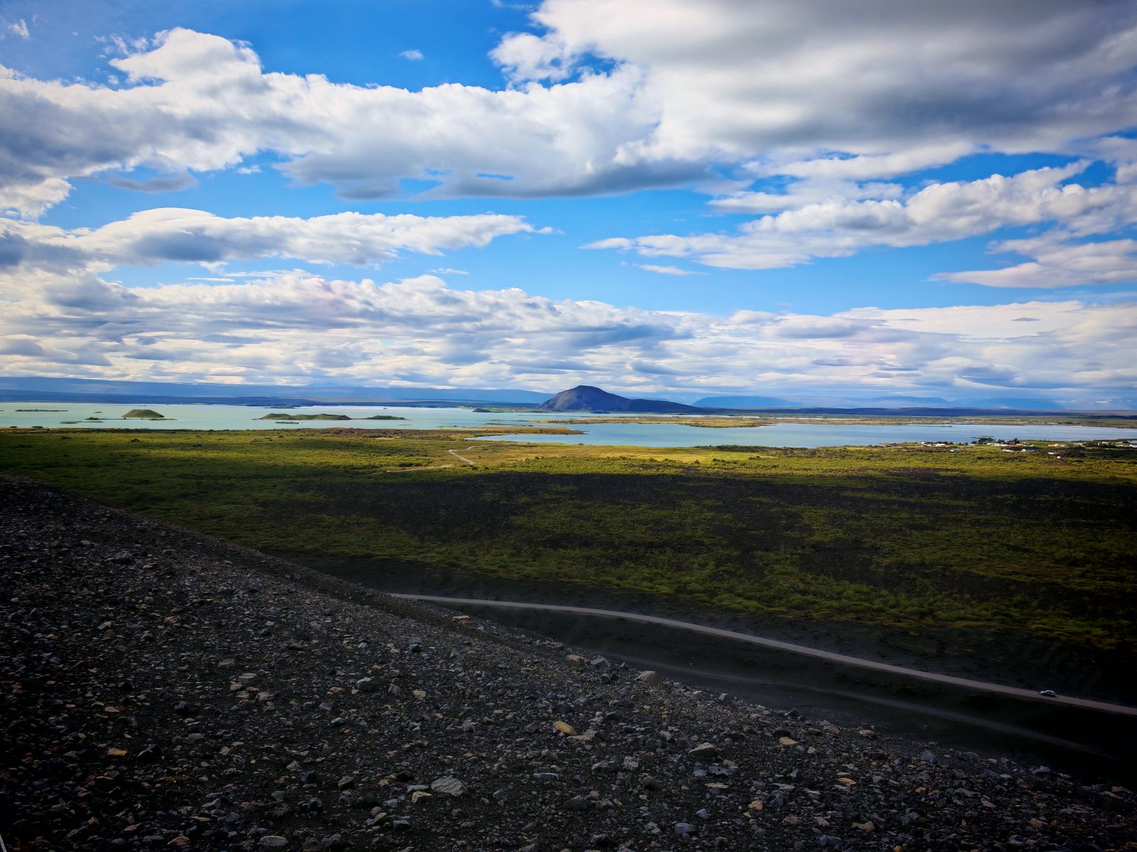 Vista panoramica di un lago e un cratere vulcanico con strada e vegetazione