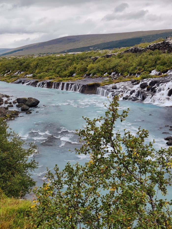 Fiume con cascate e vegetazione in un paesaggio naturale