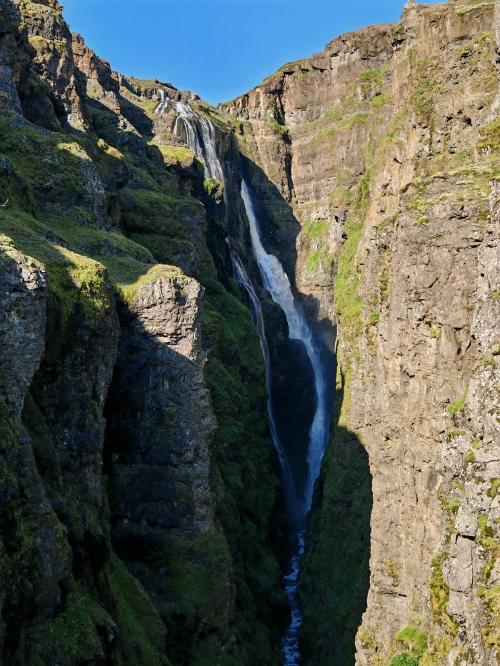 Canyon con cascata che scende fra pareti rocciose coperte di muschio