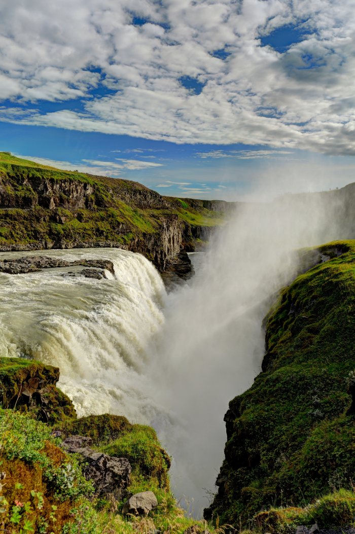 Acqua che precipita da un dirupo fra colline verdi