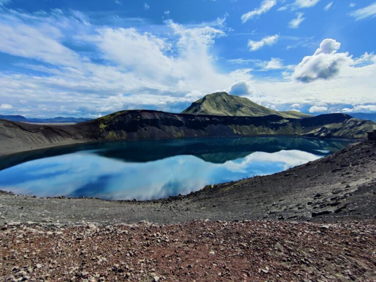 Lago craterico con riflessi perfetti e versante vulcanico sullo sfondo