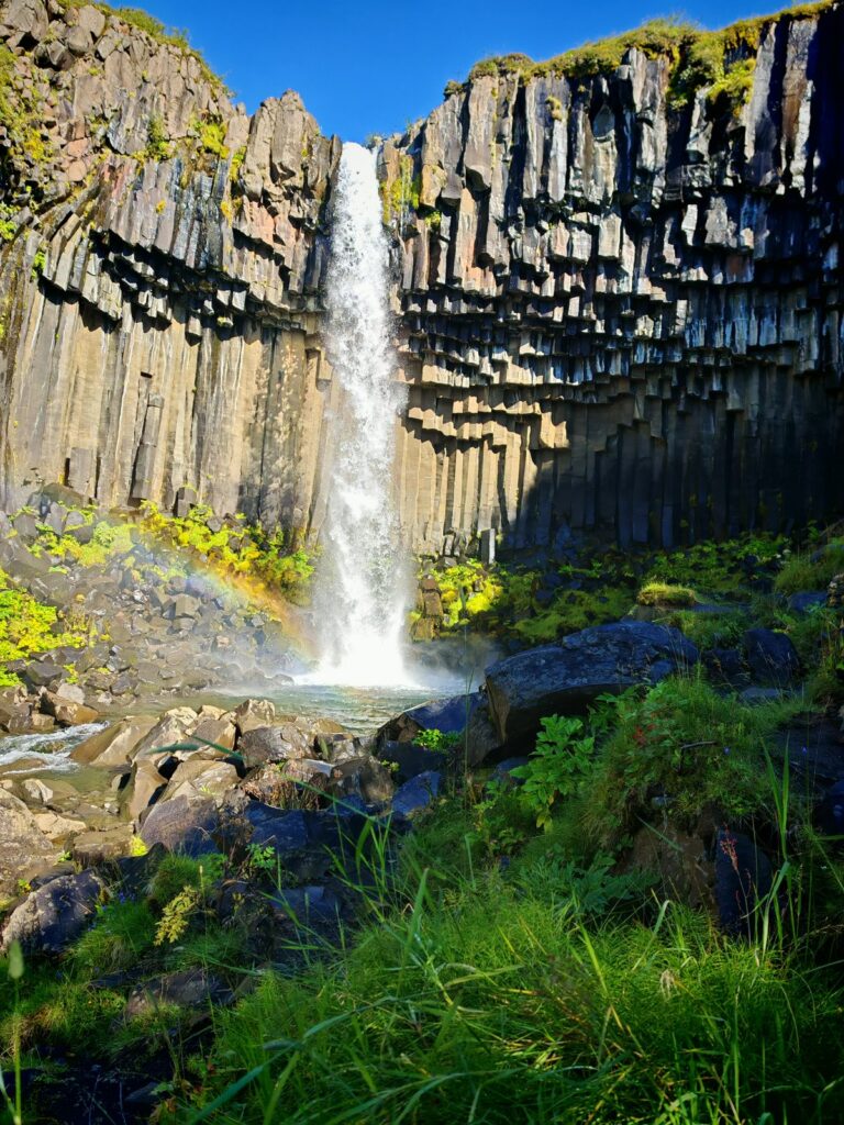 Cascata vista molto da vicino, con getto centrale e vegetazione viva intorno