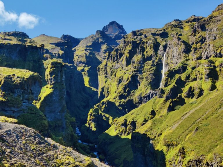 Gola rocciosa profonda con luce radente sui fianchi verdi
