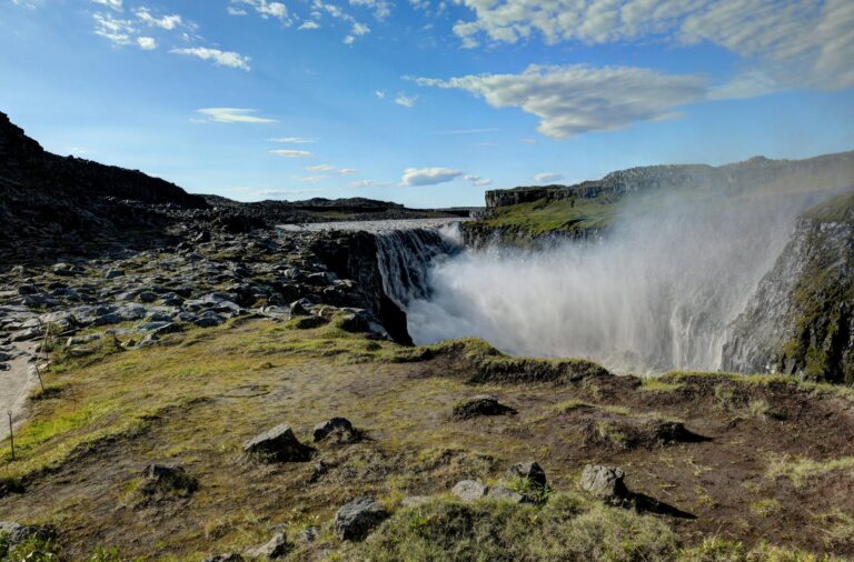 Grande cascata con spruzzi e arcobaleno sul bordo del canyon