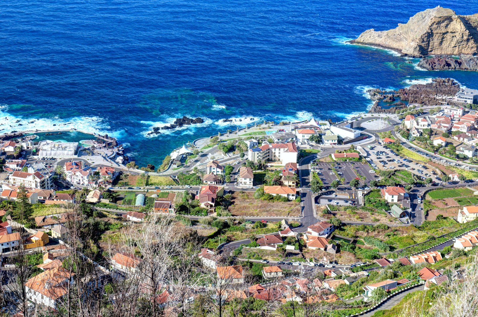 Vista dall'alto di un paese costiero con case e strade lungo il mare