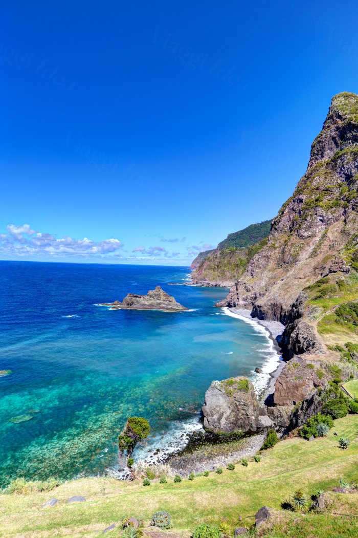 Costa rocciosa con mare turchese e cielo azzurro